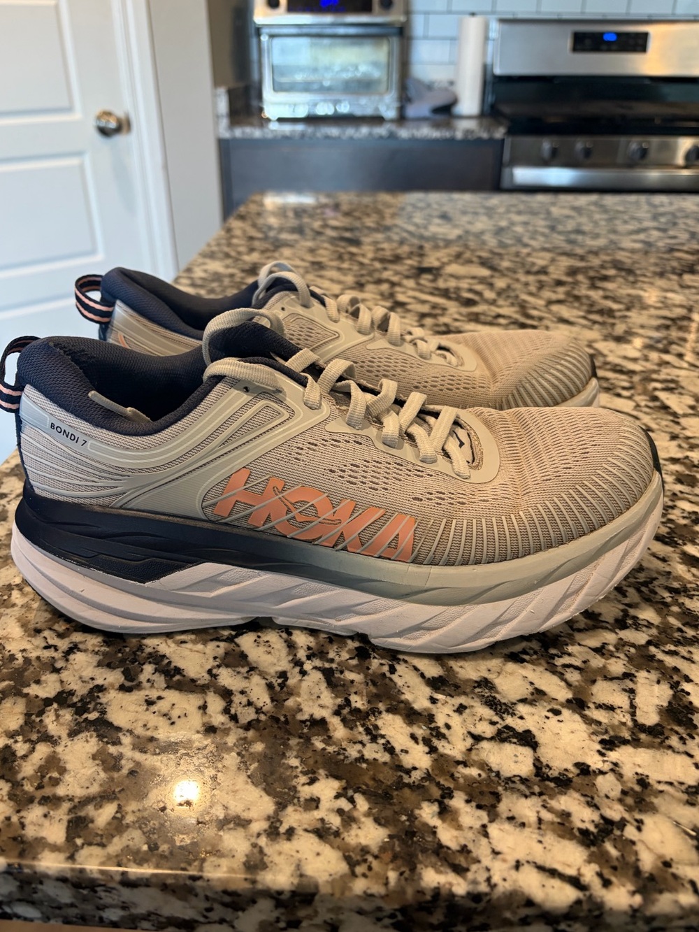 Hoka Bondi 7 woman’s Running Shoes in Light Gray with Navy and Orange Accents